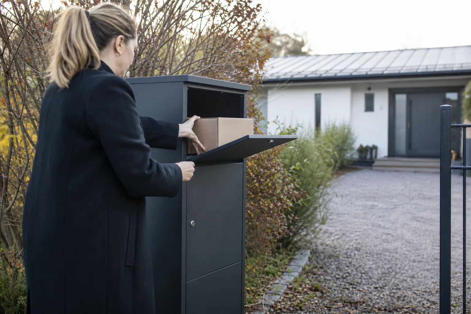 Galvaniserad och pulverlackerad paketpostlåda i grå plåt vid en svensk villauppfart